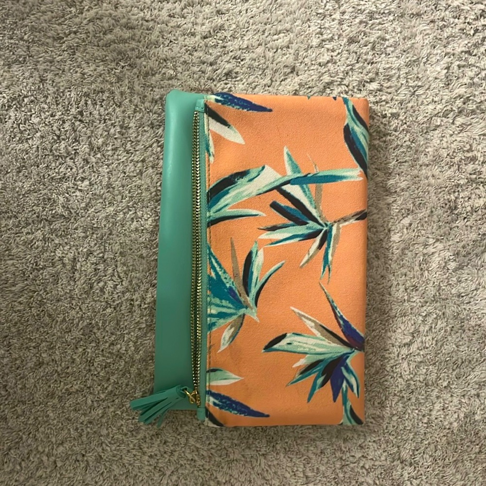 Folding pink/teal palm print clutch in great condition. One interior pocket.